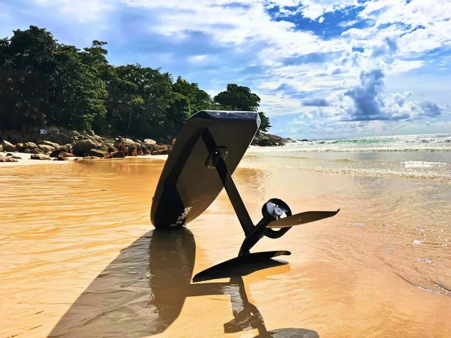 An eFoil board resting on a sandy beach