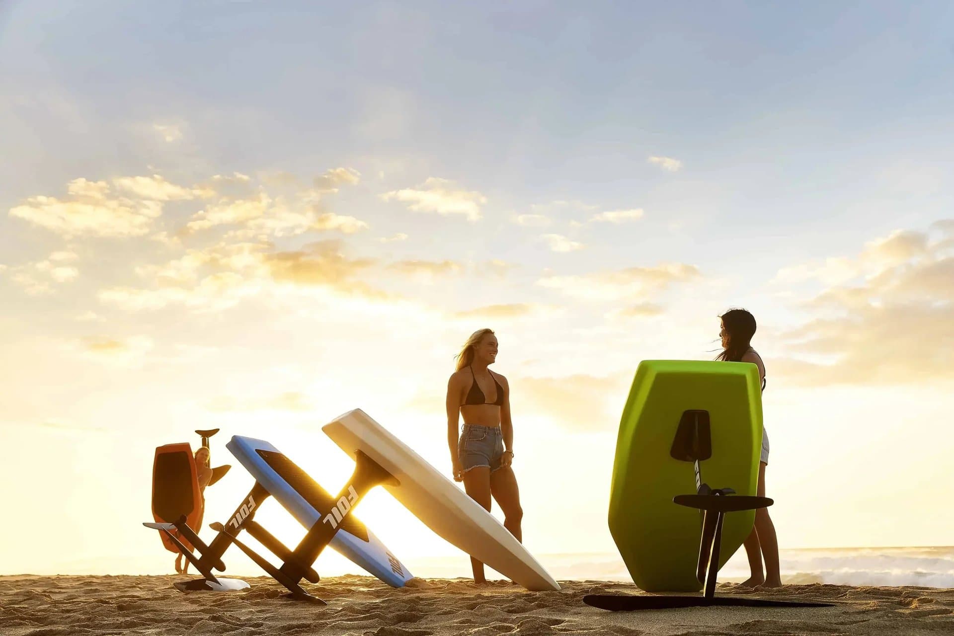 Friends with eFoil boards at sunset on the beach
